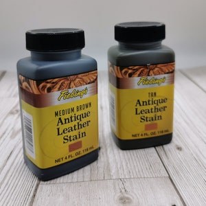 Op de afbeelding: Twee flessen Fiebing's Antique Leather Stain, &eacute;&eacute;n in Medium Brown en &eacute;&eacute;n in Tan. Elke fles bevat 118 ml (4 fl oz).
