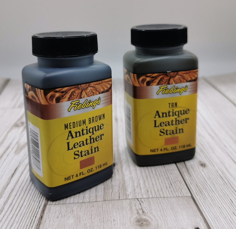 Op de afbeelding: Twee flessen Fiebing's Antique Leather Stain, &eacute;&eacute;n in Medium Brown en &eacute;&eacute;n in Tan. Elke fles bevat 118 ml (4 fl oz).
