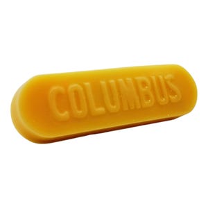 以下が含まれることがあります： 「COLUMBUS」という文字が浮き彫りになった黄色のワックスバー
