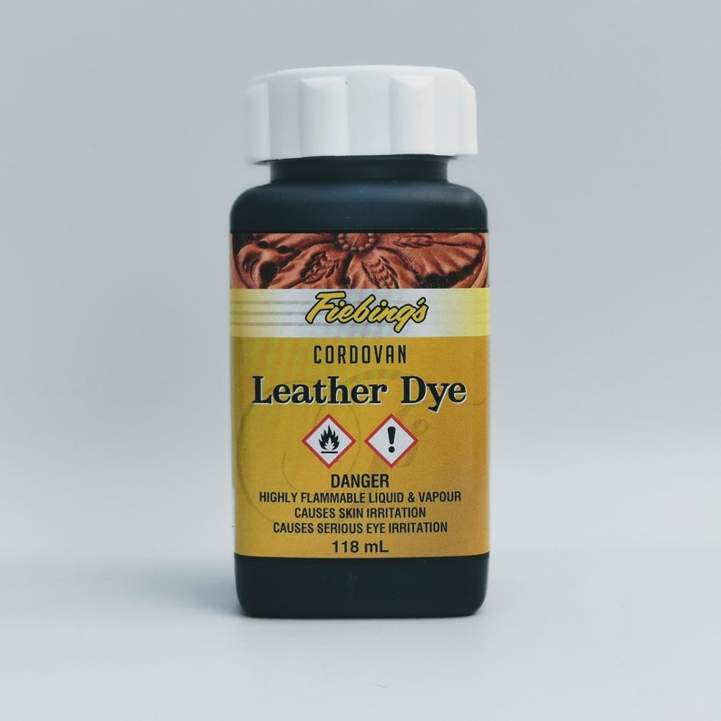 May include: A black bottle of Fiebing's Cordovan Leather Dye with a white cap. The bottle is labeled with a yellow warning label that reads "DANGER: HIGHLY FLAMMABLE LIQUID & VAPOUR CAUSES SKIN IRRITATION CAUSES SERIOUS EYE IRRITATION 118 mL".