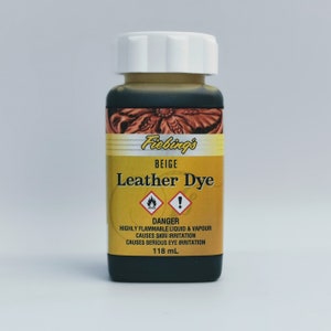 May include: A bottle of Fiebing's Leather Dye in beige. The bottle is 118 ml and has a warning label that reads "DANGER: HIGHLY FLAMMABLE LIQUID & VAPOUR CAUSES SKIN IRRITATION CAUSES SERIOUS EYE IRRITATION".