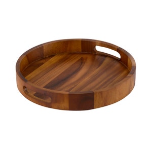 May include: A round wooden serving tray with two handles. The tray is made of dark brown wood and has a natural wood grain.