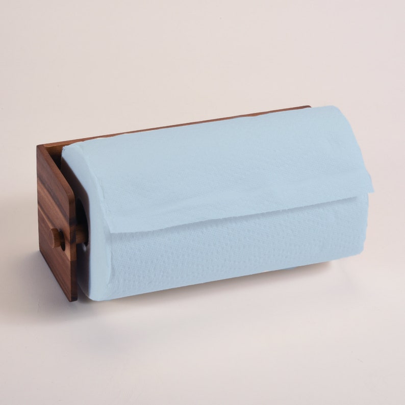 May include: A wooden paper towel holder with a light blue paper towel roll. The holder has a natural wood finish and a simple design.