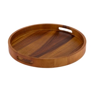 May include: A round wooden serving tray with two handles. The tray is made of light brown wood with a natural wood grain pattern.