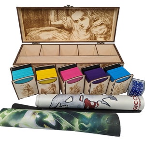 Peut inclure: Une boîte en bois avec un couvercle à charnières, ornée d'une image gravée au laser d'Alice au pays des merveilles. La boîte comporte cinq compartiments pour ranger des cartes, et un jeu de dés bleus est visible au premier plan. Deux tapis de jeu enroulés sont également inclus, l'un avec un motif vert et blanc et l'autre avec un motif blanc et rouge.