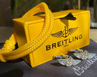 Gemelos BREITLING F-11 bañados en plata en caja de presentación.