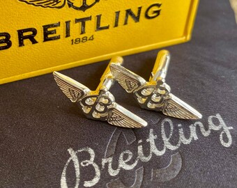 Boutons de manchette BREITLING F-11 en métal argenté dans une boîte de présentation.