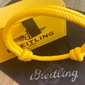 BREITLING F22 Mens adjustable sliding rope bracelet in canary yellow with presentation box.