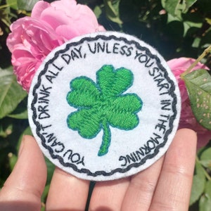 Peut inclure: Un écusson rond blanc brodé avec une bordure noire. L'écusson présente un trèfle à quatre feuilles vert et le texte "You can't drink all day, unless you start in the morning."