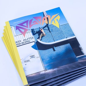 Puede incluir: Una pila de cinco revistas de skate amarillas y negras con la palabra "SLAP" en una fuente estilizada y colorida en la portada. La imagen de la portada muestra a un patinador realizando un truco en una rampa frente a un edificio de ladrillos azules.
