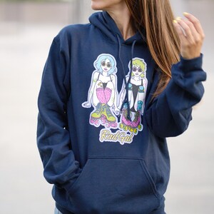 Puede incluir: Una sudadera con capucha azul marino con un gr&aacute;fico de dos mujeres en patines. El gr&aacute;fico incluye el texto "Rad Gal".