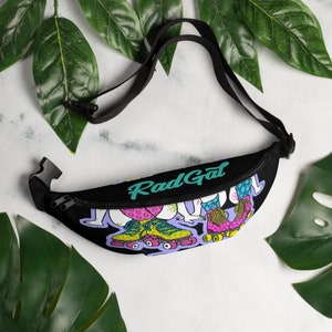 May include: Black fanny pack with a colorful illustration of roller skaters and the text "Rad Gal" in teal.
