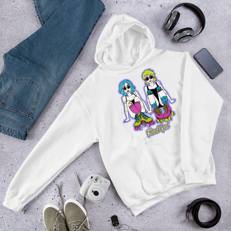 Puede incluir: Sudadera con capucha blanca con un gr&aacute;fico de dos mujeres en patines y el texto "Rad Gal".