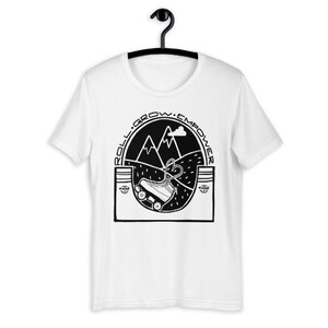 May include: White t-shirt with a black graphic of a roller skate going uphill with mountains in the background. The text "Roll. Grow. Empower" is around the graphic.