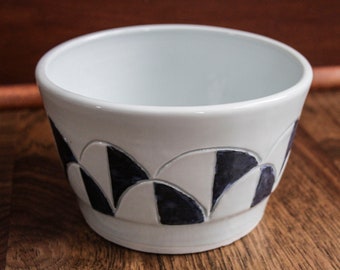 Maceta grande de porcelana con forma de galleta en blanco y negro, hecha a mano, con tallado personalizado y esmaltes combinados.