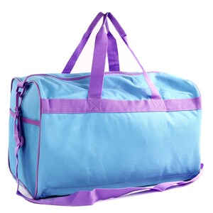 May include: A light blue duffel bag with purple straps and a mesh pocket. The bag has a zipper closure and a shoulder strap.