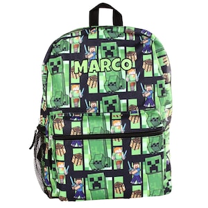 May include: Green and black backpack featuring a repeating pattern of Minecraft characters and blocks. The backpack has a front zippered pocket, a side mesh pocket, and the name "MARCO" printed in white.