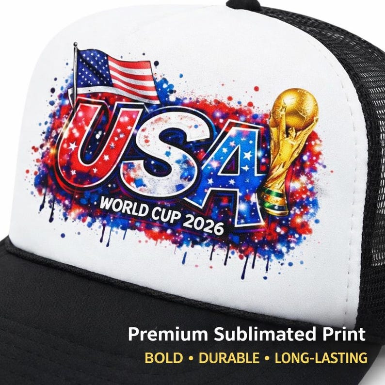 Puede incluir: Gorra de camionero en blanco y negro con un panel frontal blanco que presenta un gr&aacute;fico colorido. El gr&aacute;fico incluye el texto "USA WORLD CUP 2026" con la bandera estadounidense y un trofeo dorado. La gorra tiene una parte trasera de malla.
