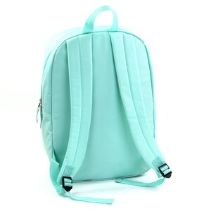 May include: A light blue backpack with adjustable straps and a zippered pocket. The backpack is made of a soft, durable fabric.