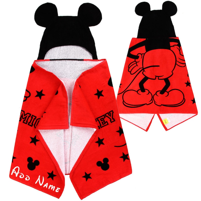 Op de afbeelding: Rode badhanddoek met capuchon met een zwart Mickey Mouse-ontwerp. De handdoek heeft een wit interieur en heeft zwarte sterren en de tekst "Mickey" en "Mouse".