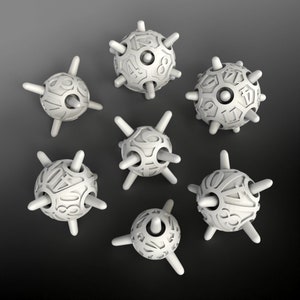 May include: Seven white dice with numbers on each face. The dice are shaped like spheres with spikes protruding from the surface.