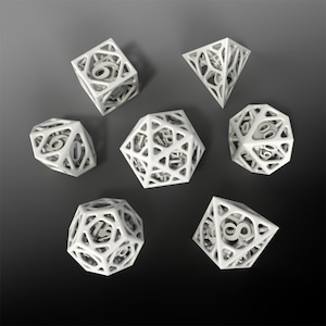 May include: A set of seven white, geometric dice with numbers on each face. The dice are made of a translucent material and have a hollow, cage-like design.