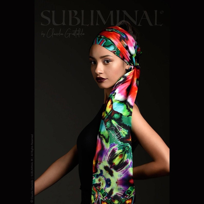 May include: A woman wearing a black top and a colorful silk scarf with a floral pattern. The scarf is tied around her head and neck. The text "SUBLIMINAL" is written in white letters on a black background above the woman's head.