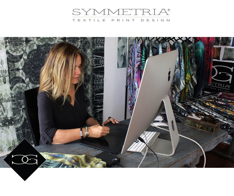 May include: A woman working on a digital tablet at a desk, with a large computer monitor in front of her. The image includes the text "SYMMETRIA TEXTILE PRINT DESIGN" and a logo. Colorful fabric designs hang in the background.