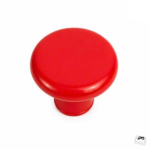 Peut inclure: Bouton de meuble rouge vif avec un dessus arrondi et une base cylindrique courte. Le bouton a une finition brillante et est posé sur un fond blanc. Convient aux tiroirs et aux armoires.