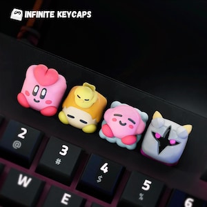 May include: Four colourful keycaps featuring cartoon characters. The keycaps are pink, yellow, pink, and grey. The characters are a pink creature with a heart, a yellow creature with a frown, a pink creature with a smile, and a grey creature with a star.