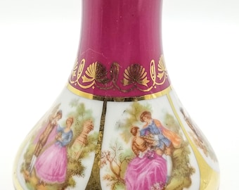 Può includere: Un vaso decorativo con un corpo magenta intenso e una sezione bianca con scene romantiche. Il vaso è rifinito con dettagli dorati e ha una base svasata e un collo sottile. Le scene raffigurano figure in abiti d'epoca.