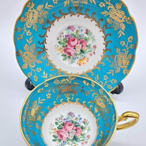 Foley teacup and saucer-blue background, gold detailing with floral bouquet in center, vintage bone china made in England