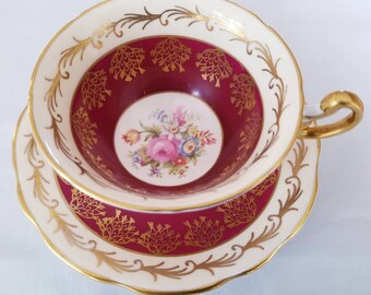 Foley teacup and saucer- dark burgundy with floral bouquet in center,  gold scrolls pattern