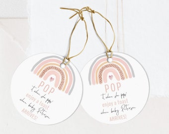 May include: Two round pink and grey rainbow-themed gift tags with the text "POP" and "When she pops enjoy a toast when baby [name] arrives!" printed on them.