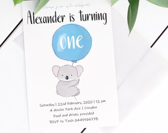 Puede incluir: Una invitación de cumpleaños azul y blanca con un koala sosteniendo un globo azul que dice "one". La invitación incluye el texto "Please join us to celebrate Alexander is turning one" y los detalles de la fiesta.