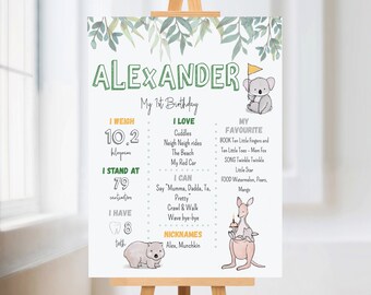 May include: A green and white printable first birthday sign for a boy named Alexander. The sign features a koala, a wombat, and a kangaroo. It includes details about the child's weight, height, favorite foods, and activities.