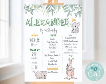 May include: A green and white printable first birthday sign for a boy named Alexander. The sign features a koala, a wombat, and a kangaroo. It includes details about the child's weight, height, and favorite things. The sign is personalized with the text "Personalize with Coril".