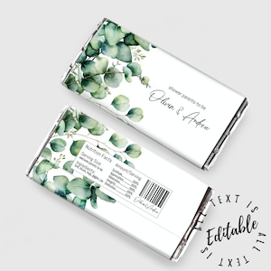 May include: White chocolate bar wrapper with a watercolor design of eucalyptus leaves. The wrapper has the text "shower parents-to-be Olivia & Andrew" printed on it. The back of the wrapper has a nutrition facts label with the text "Gratitude, Appreciation, Admiration, Integrity, Dedication" printed on it.