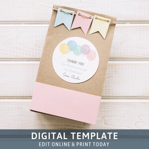 May include: A brown paper bag with a pink and white stripe at the bottom. A round sticker with pastel colored balloons and the text "THANK YOU for Celebrating my 1st Birthday! Love, Charlie" is attached to the bag.