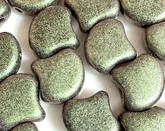 May include: Close-up of a collection of olive green, irregularly shaped beads. Each bead has a textured surface and a hole for stringing. The beads are scattered on a white surface, creating a visually appealing arrangement.