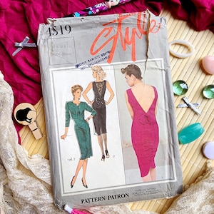 Op de afbeelding: Vintage naaipatroon met de titel "Style" en het nummer 4519. Het patroon bevat illustraties van drie verschillende jurk ontwerpen. De omslag is grijs met rode en oranje tekst, en het patroon is voor maten 8, 10 en 12.