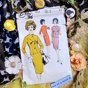 May include: Vintage Le Roy sewing pattern featuring illustrations of women's suits in yellow, orange, and pink. The pattern is labeled "3010" with a size 12 and bust measurement of 32 inches. The image includes decorative elements like flowers and a "one of a kind" tag.