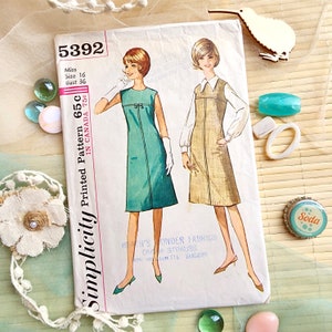 Op de afbeelding: Een vintage Simplicity naaipatroon voor een jurk, met twee modellen die verschillende versies van het ontwerp dragen. Het patroonnummer is 5392, en de prijs is 65 cent. Het patroon is voor een meisje, maat 16, borstomvang 36.