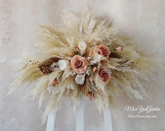 May include: A bouquet of dried pampas grass and blush pink roses, arranged on a white easel. The bouquet is decorated with gold accents and dried leaves. The text "Miss You Garden" and "https://www.etsy.com" is visible at the bottom of the image.