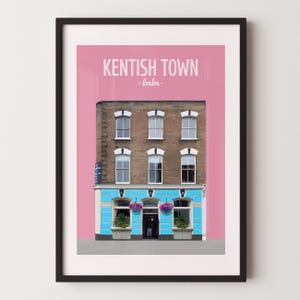 May include: A framed wall art print featuring a brick building with a bright blue storefront against a solid pink background. The text reads KENTISH TOWN - london. The building has six windows on the upper floors and a central entrance door.