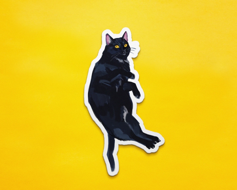 May include: A black cat sticker with yellow eyes, the cat is curled up in a ball with its paws tucked in.