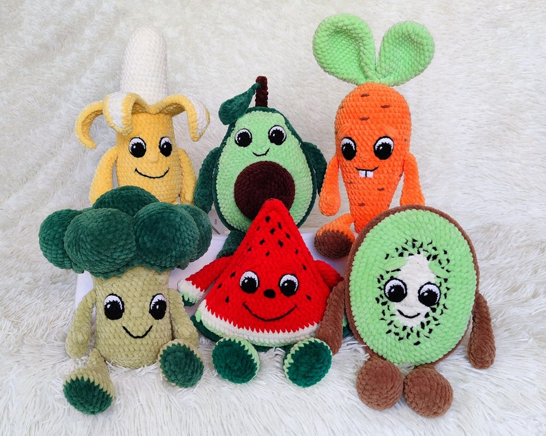 May include: A set of six crocheted plush toys shaped like fruits and vegetables. The toys include a banana, avocado, watermelon, carrot, broccoli, and kiwi. Each toy has a friendly face and is made with soft, colorful yarn.