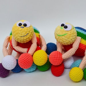 Pu&ograve; includere: Due giocattoli ragno all'uncinetto color arcobaleno con grandi occhietti. Ogni giocattolo ha diverse palline colorate attaccate alle sue zampe.