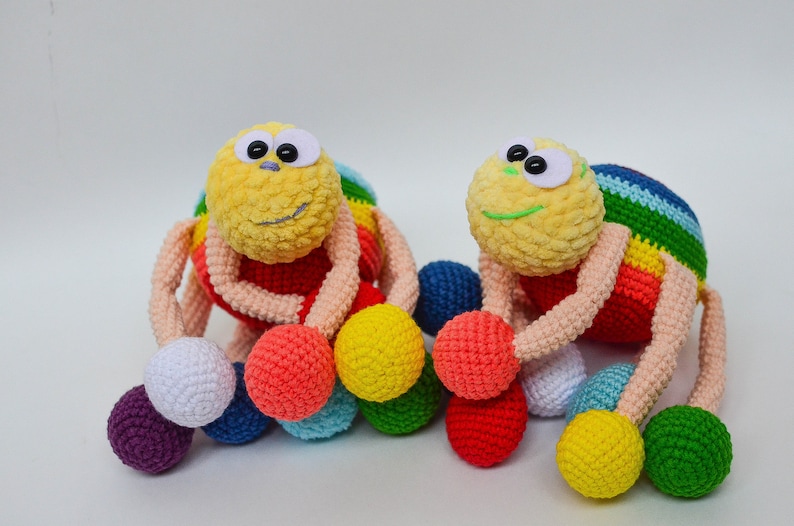 Pu&ograve; includere: Due giocattoli ragno all'uncinetto color arcobaleno con grandi occhietti. Ogni giocattolo ha diverse palline colorate attaccate alle sue zampe.