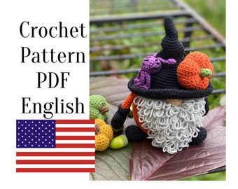May include: A crochet gnome wearing a black pointed hat adorned with a small purple spider and an orange pumpkin. The gnome features a long, curly light gray beard, orange sleeves, and black hands and feet. Text reads Crochet Pattern PDF English.